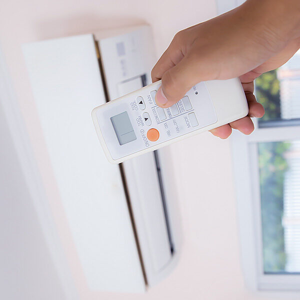 Close up hand and remote control air condition