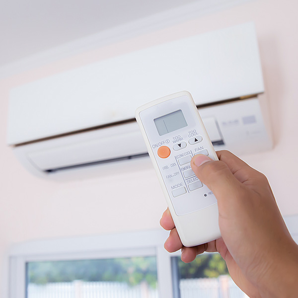 Close up hand and remote control air condition