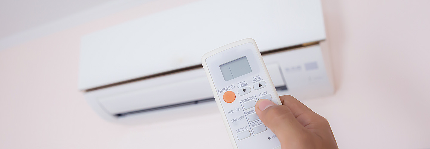 Close up hand and remote control air condition.