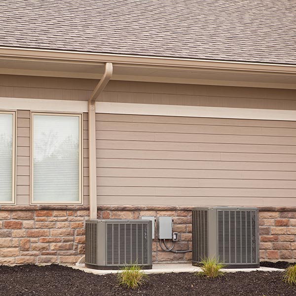 Two new high efficiency air conditioners at the back of a building