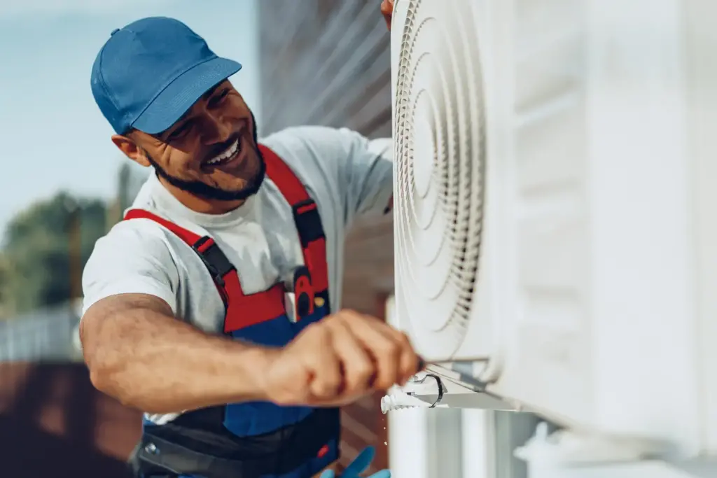 man checking an outsdie air conditioner unit