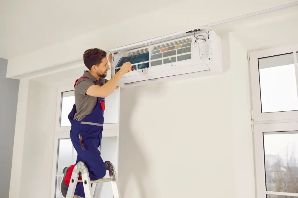 man cleaning air conditioner