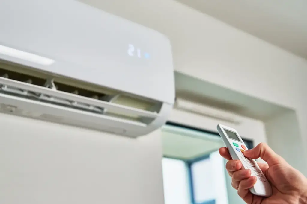 A person adjusting the temperature in an air conditioning system